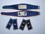 un ensemble composé de trois insignes militaires et d'une ceinture, posé sur un fond blanc