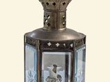 une petite lanterne en métal avec un couvercle en verre