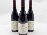trois bouteilles de vin posées sur une table blanche