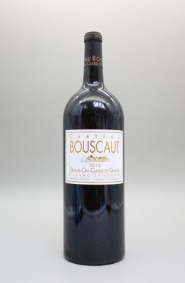 une bouteille de vin posée sur une table blanche