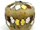 a small box with flowers on it on a white surface