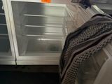 an open refrigerator in a kitchen with a dishwasher on the counter