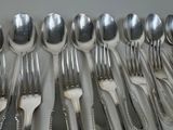a lot of silver spoons and forks on the table