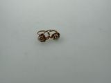 two gold rings sitting on top of a white surface