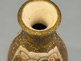 a small vase with a design on it on a table