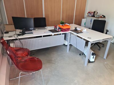 un bureau avec deux ordinateurs et une chaise dans la chambre