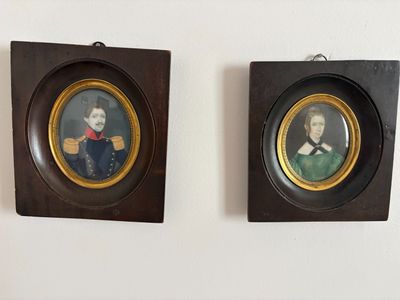 deux portraits encadrés représentant un homme et une femme, accrochés au mur