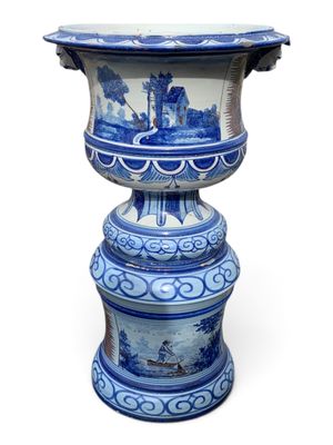 a blue and white vase with a man on a boat on it
