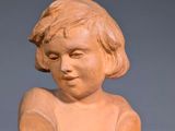 an image of a small statue of a child on a wooden base