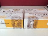 deux cartons de vin posés sur un comptoir, à côté de bouteilles de vin
