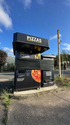 a sign that says pizzas on the side of the road