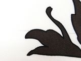 a close up of a black and white flower on a white shirt