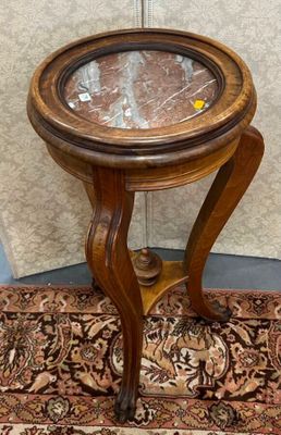une petite table en bois avec un plateau en verre, posée sur un tapis