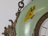 a clock hanging from a chain on the wall