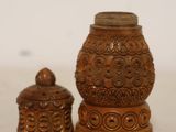 two wooden jars with carvings on them on a table