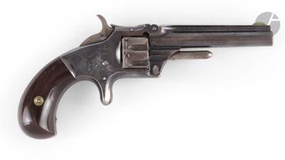 un vieux revolver avec un manche en bois sur fond blanc
