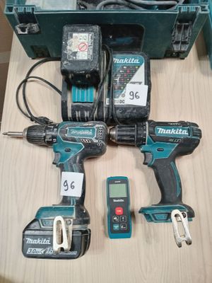 Deux Makita sont posées sur une table à côté d'une boîte à outils