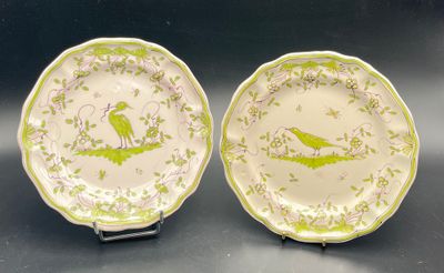 pair of green and white plates with birds on them sitting on a table