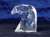 a clear glass sculpture of a bird on a black surface