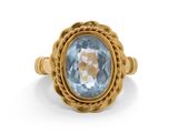 Gros plan sur une bague en or ornée d'une topaze bleue