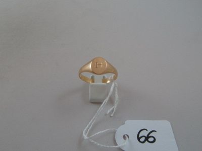 a gold ring on a white table with a price tag