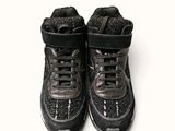 a pair of black shoes that are on a white surface