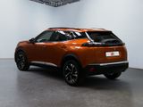 an orange car is parked in a large room with a white wall