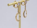 pair of gold earrings with diamonds on a gold plated stand