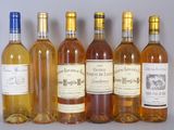 six bottles of wine are lined up in a row on a table