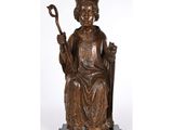 une statue en bronze représentant un homme assis sur une chaise, tenant une canne