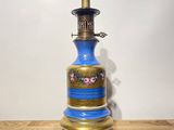 a blue and gold vase sitting on top of a wooden table