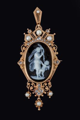 une image représentant un pendentif sur lequel figure une femme tenant un enfant dans ses bras