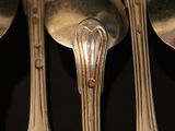 five silver spoons sitting on top of each other