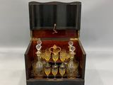 une image représentant une boîte en bois remplie d'objets en verre, sur fond blanc