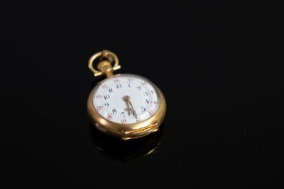 une montre de poche antique sur une surface noire avec un fond noir