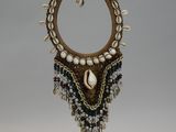 a close up of a necklace on a stand on a white background