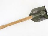 a shovel with a wooden handle on a white surface