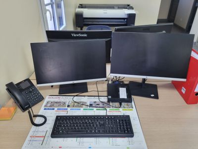 two computer monitors and a keyboard on a desk