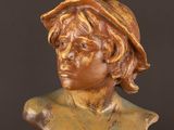a close up of a bronze bust of a man wearing a hat