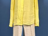 mannequin with yellow shirt and pants on display against a blue background