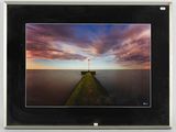 photograph of a picture of a pier with a sunset in the background