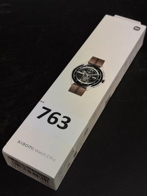 someone is holding a watch in a box on a table