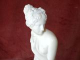 a white statue of a boy with a flower in his hand