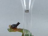 un vase en verre sur lequel est perché un oiseau