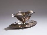 un plateau en argent orné d'une fleur, posé sur une table