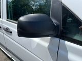 a side view of a white van with a dog in the window