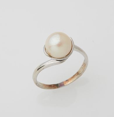 a white pearl and silver ring on a white background