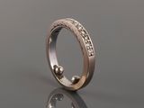a close up of a wedding ring with diamonds on a reflective surface