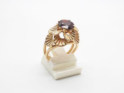 a close up of a gold ring with a garnetite stone