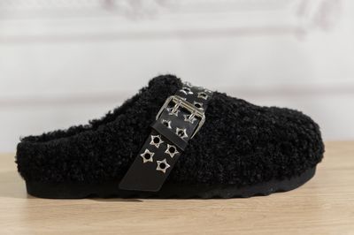 black slippers with stars on them sitting on a wooden table